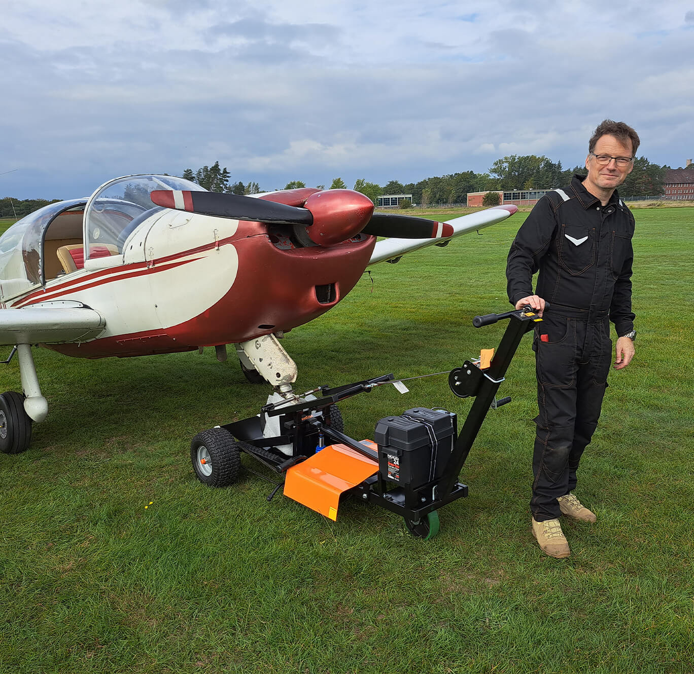 man pulling aircraft with airtug on firm grass