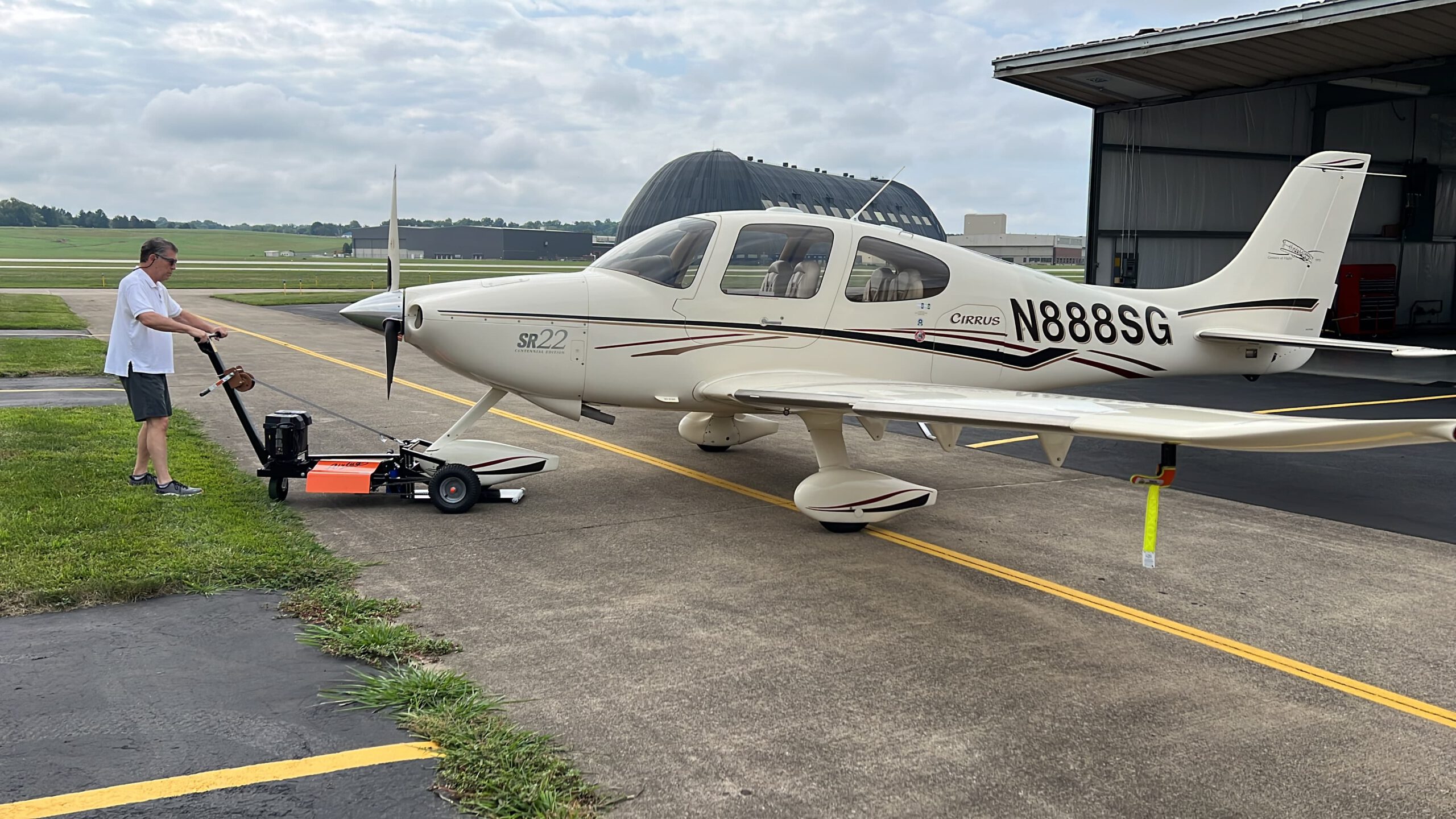 airtug pulling an aircraft outside of a hanger